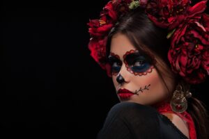 White sugar skull Dia De Los Muertos on poster for Halloween party with creative make-up or holiday on dark background with copyspace. Beautiful Model, close up in studio.