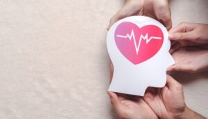 hands holding paper brain and red heart pulse, brain stroke, world heart day, world mental health day, Alzheimer and wellness concept